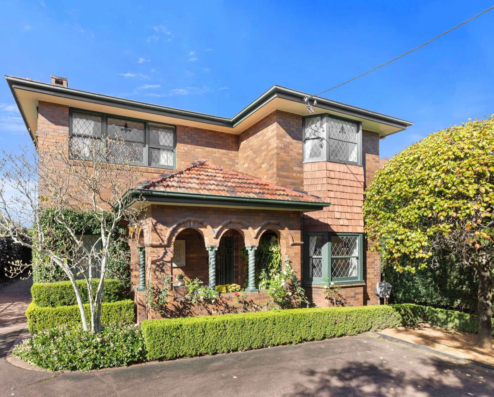 Two-storey double-brick facade with arched portico at 32 Wallis Avenue
